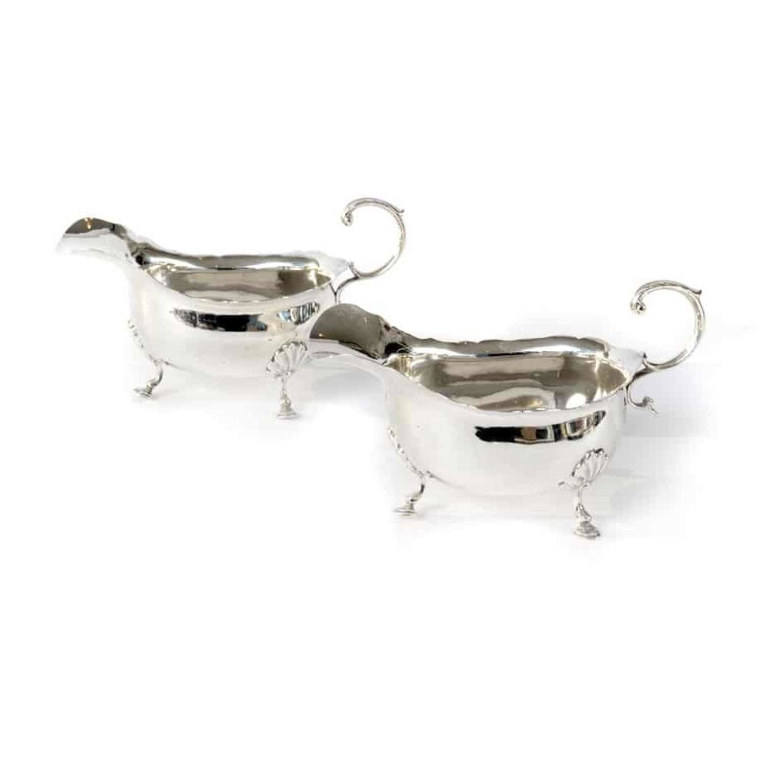 Pair of silver sauce boats with shaped edge