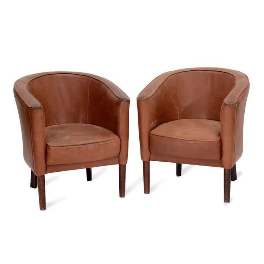 A pair of tan leather tub chairs by Heal’s