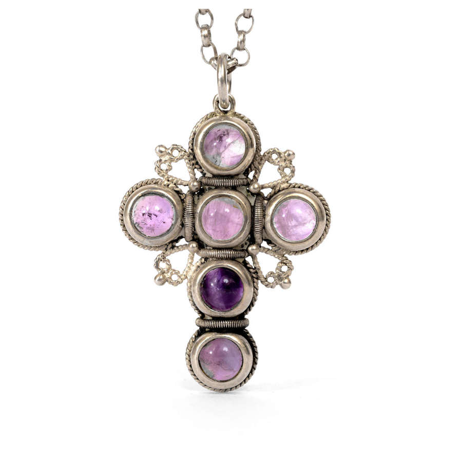 A silver and amethyst cross on a long silver chain